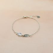 Single sterling silver marquise tag bracelet with small round 6mm sky blue birthstone.