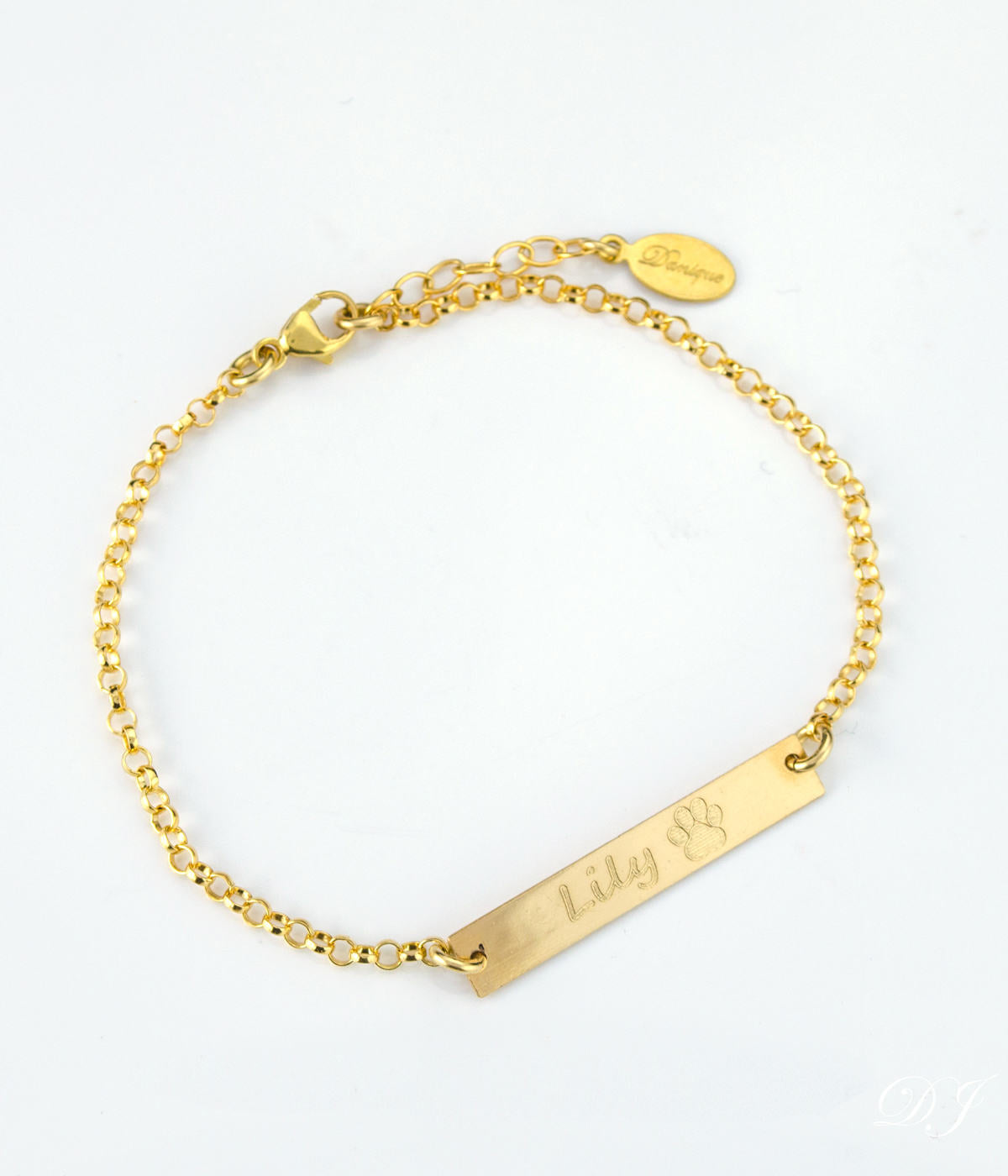 Single gold filled paw print with name engraved in script font. 