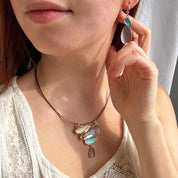 Model wears boho abstract teardrop matching necklace and earring set.