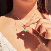 Model wearing a white lace blouse holds Dainty Large Oval Blue Amazonite Bezel Set Pendant on a gold filled satellite chain. Stress Relief Crystal Gemstone Jewelry Necklace, Natural Amazonite Gemstone, Soothing Crystal Necklace, Ocean Jewelry