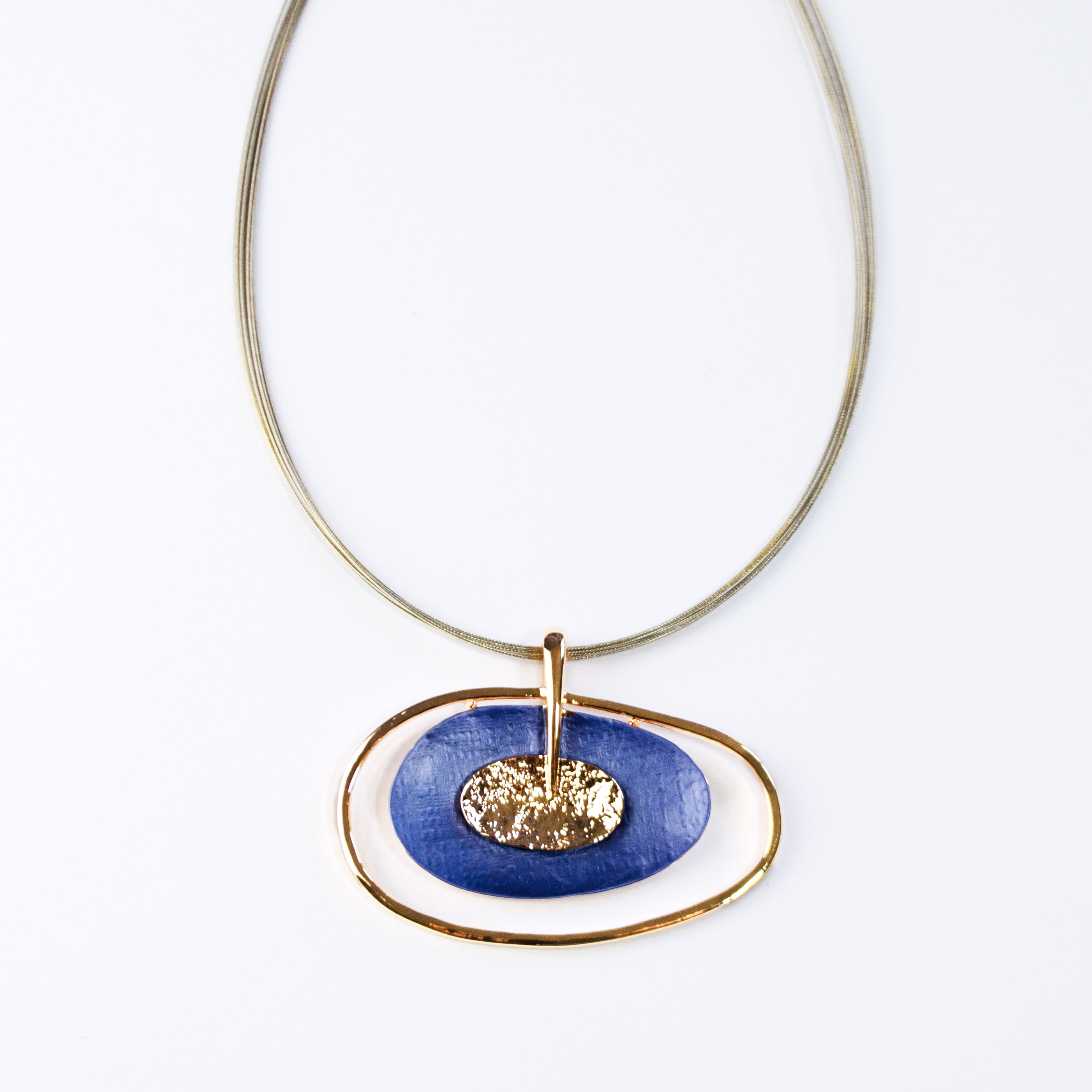 rose gold plated Open Oval Pendant with two textured overlapping oval disks in the center, painted in blue enamel and sitting on a brown steel wire chain against a white background