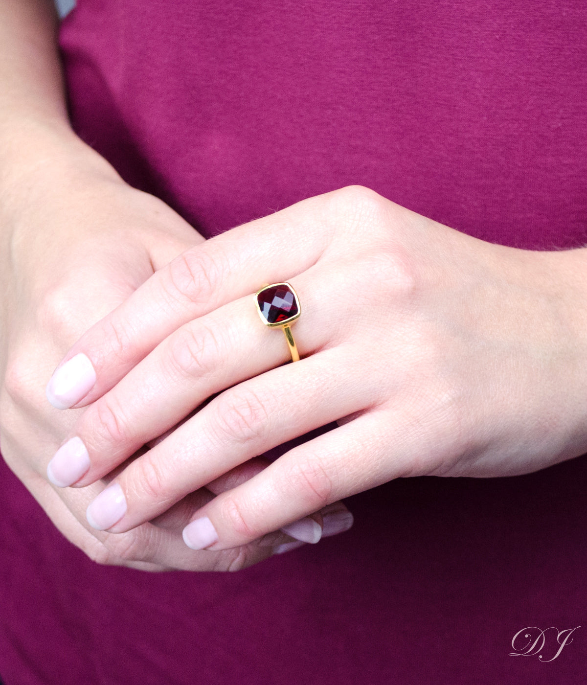 A model wearing a Natural Garnet cushion bezel rings with January Birthstone. These rings are available in Garnet, Purple Amethyst, Aquamarine, Clear Quartz, Emerald, Moonstone, Ruby, Sapphire, Fire Opal, Blue Topaz. Ready for gift giving in Danique Jewelry Branded Box. Available in Yellow or Rose gold or in Sterling Silver