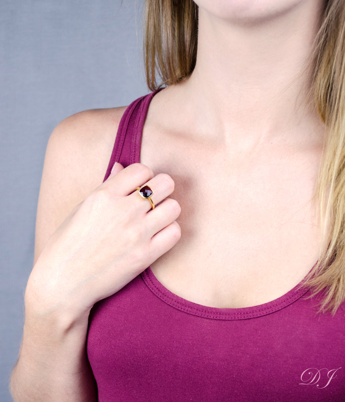 Model is wearing a Garnet gold plated cushion bezel square stacking ring 