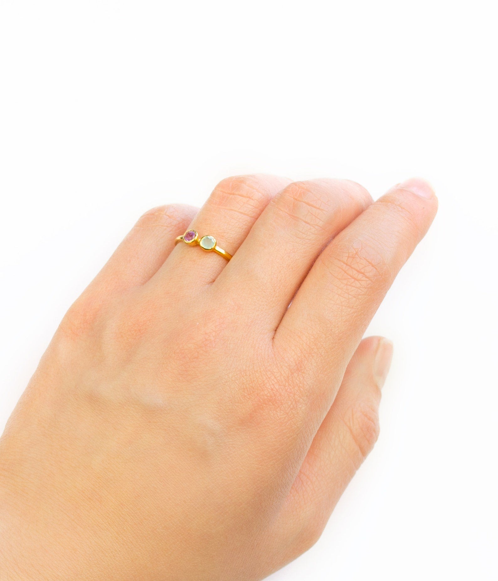 Model is wearing a single gold filled dual birthstone ring featuring ruby and aqua chalcedony. 