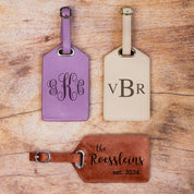 3 luggage tags in lavender, nude and cinnamon sit on a wood background. Each is engraved with a different monogram style. travel gift, personalized travel accessory, engraved leather travel label, personalized luggage identification tag, custom name baggage tag