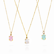 Three Oval Cabochons Bezel Set into 925 Sterling Silver Pendants Plated in 18k Vermeil Gold sitting on 14K Gold Filled Chains. From Left to Right: Pink Chalcedony and Cable Chain, Moonstone and Satellite Chain, Aqua Chalcedony and Cable Chain.