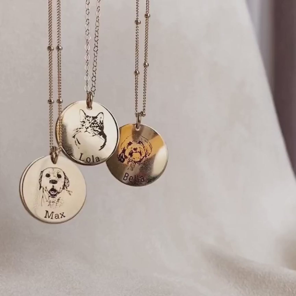 3 engraved pet portrait necklaces dangle against a pale background. Each necklace is laser engraved and shows the details and features of 2 dogs and a cat. We capture every detail from a high resolution photo you provide of your choice and engrave them with the pet's name underneath. Optional engravings can be applied on the back side of the pendant. Designed for daily wear, these necklaces are sure to last a lifetime and honor your furry family member! Available in sterling silver, rose gold or gold filled