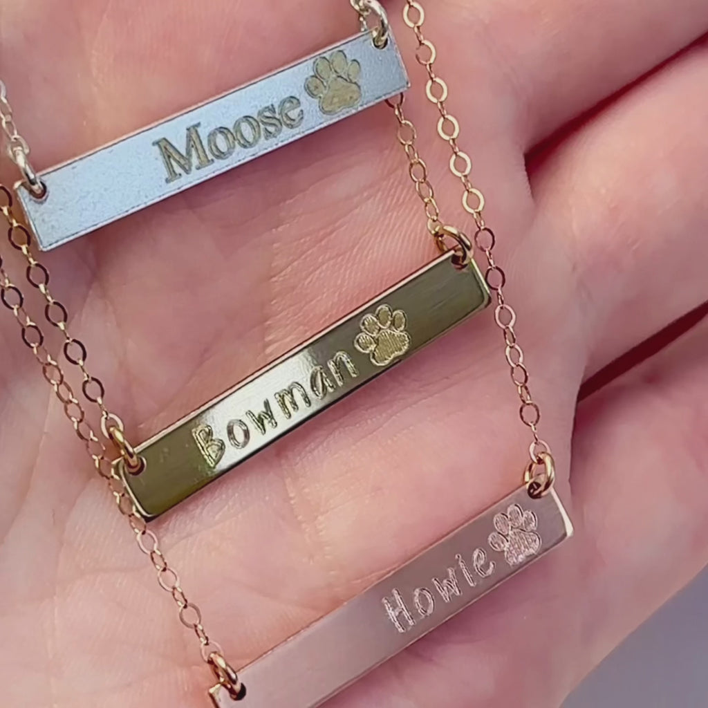 Video of Multiple paw print bar necklaces in a variety of fonts. Pet memorial bar necklace, engraved pet jewelry, custom pet name necklace, sterling silver bar necklace, gold-filled pet necklace, rose gold-filled necklace, personalized pet remembrance gift, dog mom gift, pet owner jewelry, pet tribute necklace, engraved pet charm