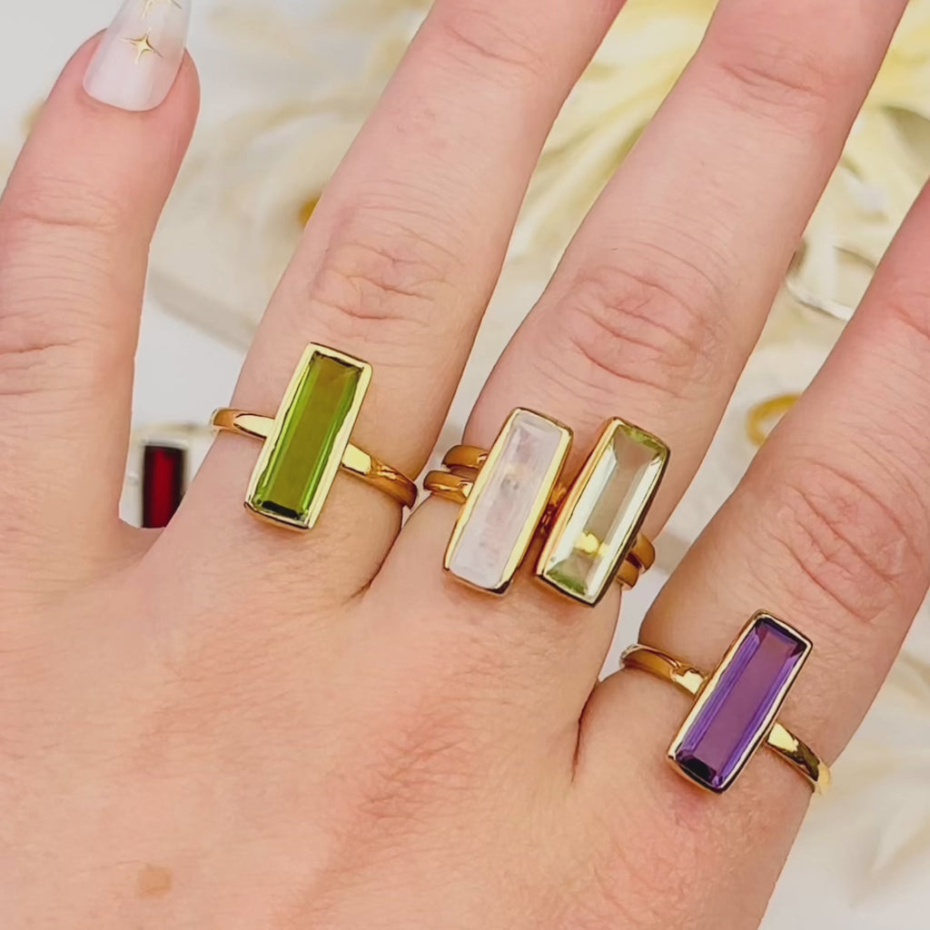 A video shows a stackable set of gemstone bar rings, personalized birthstone ring, unique birthstone ring, modern, minimalist, natural birthstone bar ring, birthday gift with birthstone, gemstone birthday gift for january, february, march, april, may, june, july, august, september, october, november, december, traditional birthstone gift