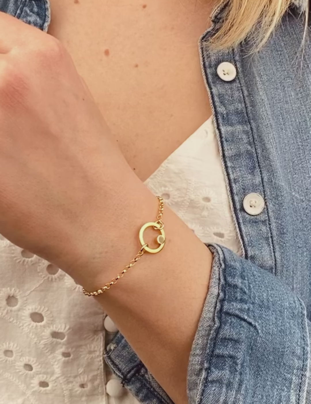 Model is wearing a gold plated open circle pendant charm birthstone bracelets featuring clear quartz birthstones. april birthstones. 