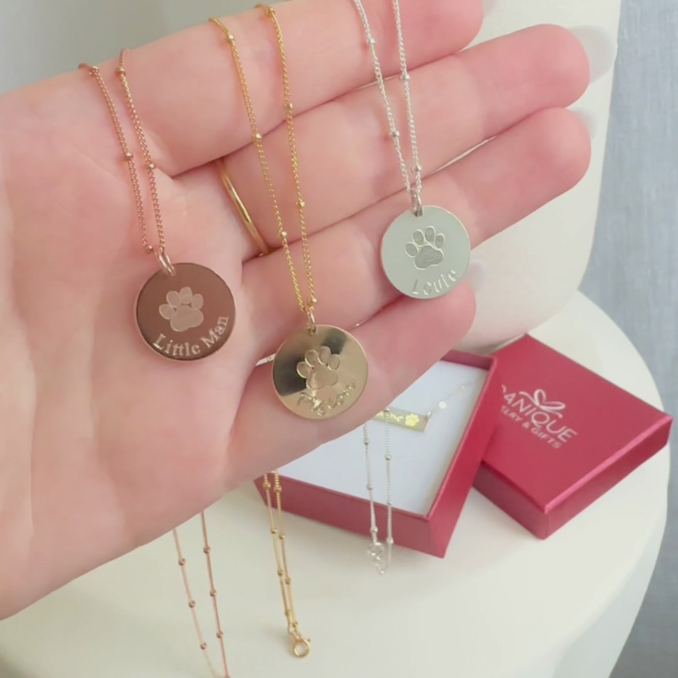 A video showing a variety of engraved paw print disc necklaces. Personalized paw print necklace, custom pet lover gift, pet loss gift, memorial for pet, in memory of dog, personalized cat loss video, personalized disc necklace sterling silver, rose gold, gold, dainty disc necklace, tasteful memorial gift for loss of pet