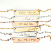 A set of assorted bar necklaces in gold, silver and rose gold against a white background. Customized name necklaces in multiple fonts, swirly name necklace, simple name necklace, custom nameplate necklace