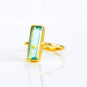 Blue Topaz gemstone bar ring, December birthstone alternative, rich blue Topaz, unique minimalist design, bezel-set Topaz, Adira Series, stylish blue jewelry, elegant Topaz ring, eye-catching gemstone, fashion-forward Topaz