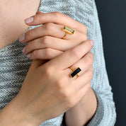 A person wears a gemstone bar ring on the middle finger of each hand. Green amethyst gemstone bar ring, black onyx gemstone bar ring, gold green amethyst ring, silver green amethyst ring, rose gold green amethyst ring, gold black onyx ring, silver black onyx ring, rose gold black onyx ring