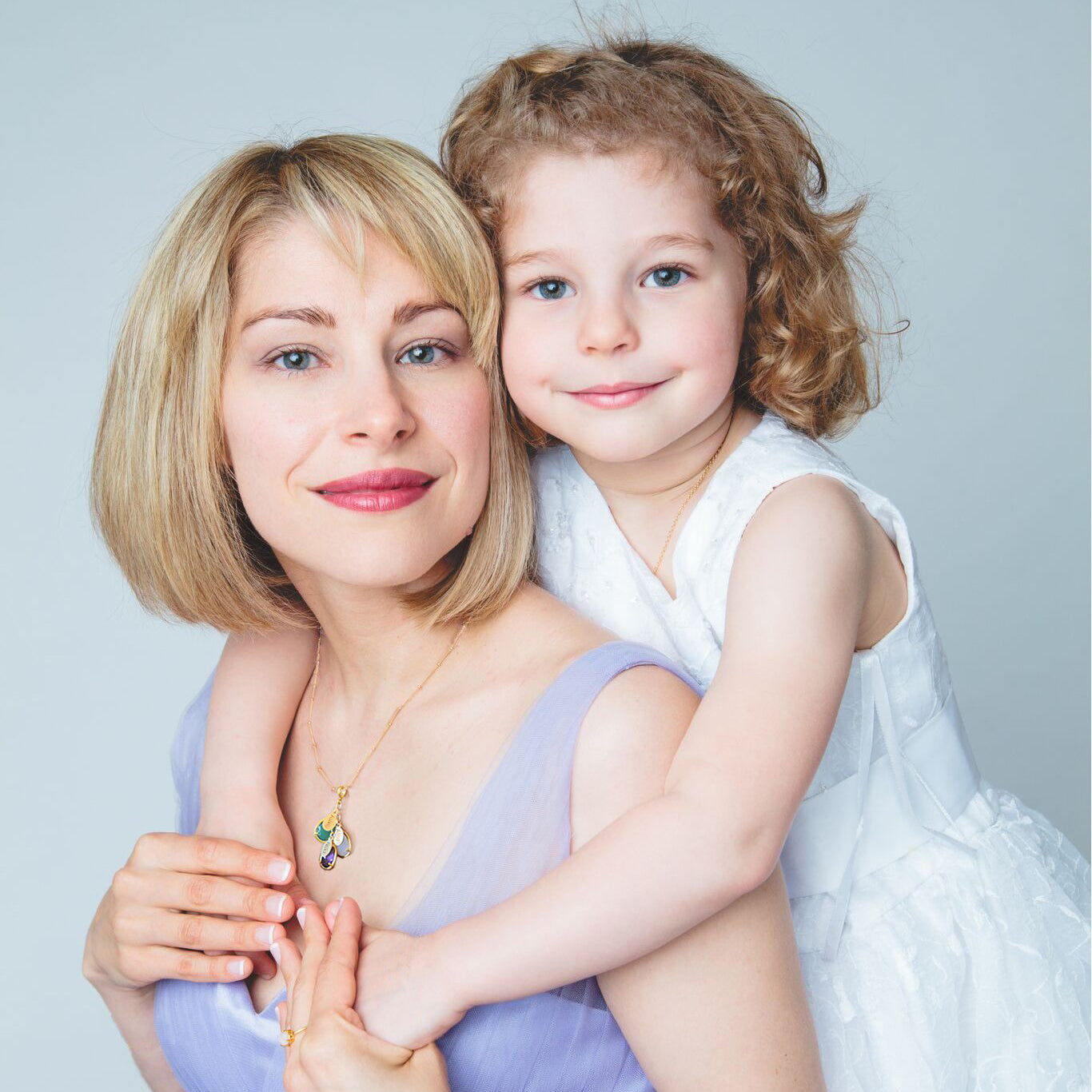 Mother wearing an 18k vermeil gold customized teardrop birthstone pendant necklace while sitting with her daughter