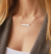 A person in a tan shirt wears a bar necklace. Custom engraved pet bar necklace, sterling silver pet keepsake, gold-filled bar necklace, rose gold pet necklace, personalized pet loss jewelry, pet memorial gift, dog lover necklace, pet owner gift, pet name necklace, engraved front or back, pet remembrance charm