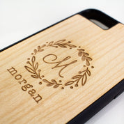 Close up birch phone holder with wreath monogram. Phone case, engraved phone protector.