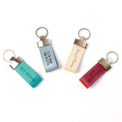 Four Leather Loop Keychains in Turquoise, Blue Gray, Off-White, and Magenta engraved with "Boy Mom", "To the Moon and Back", Couples name's and a Bible Verse. Custom bible verse keychain, gifts for travelers, customized traveler gift, personalized gift for traveler, gift for person who loses their keys, personalized key holder, custom engraved leather keychain