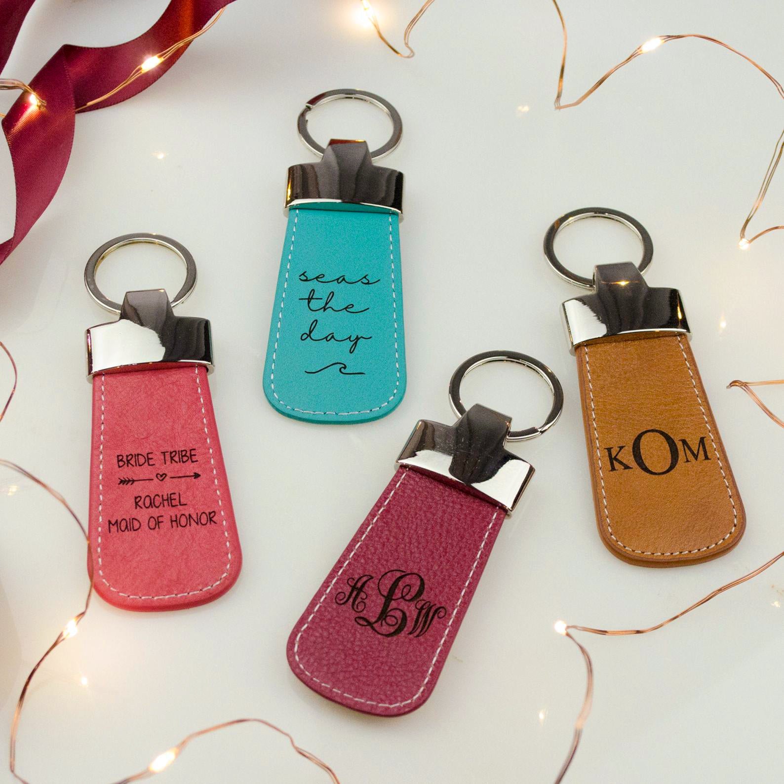 Four leather paddle engraved keychains. Great for wedding parties, groomsman, bridesmaids or for any special loved one. Watermelon with bride tribe design. Turquoise with seas the day and wave pattern. Raspberry keychain with elegance monogram. Honey keychain with formal KOM monogram